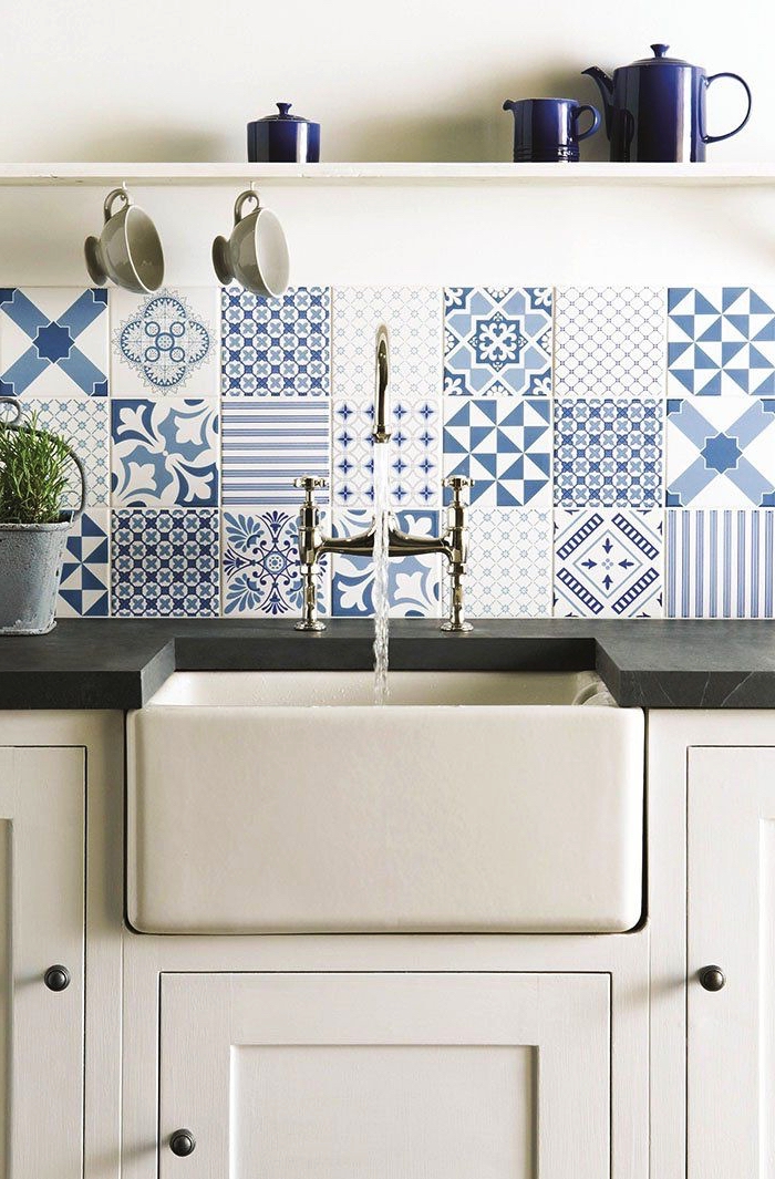 des carreaux de ciment patchwork en nuances de bleu posés en crédence, une crédence lumineuse qui apporte une touche rustique à la cuisine blanche 