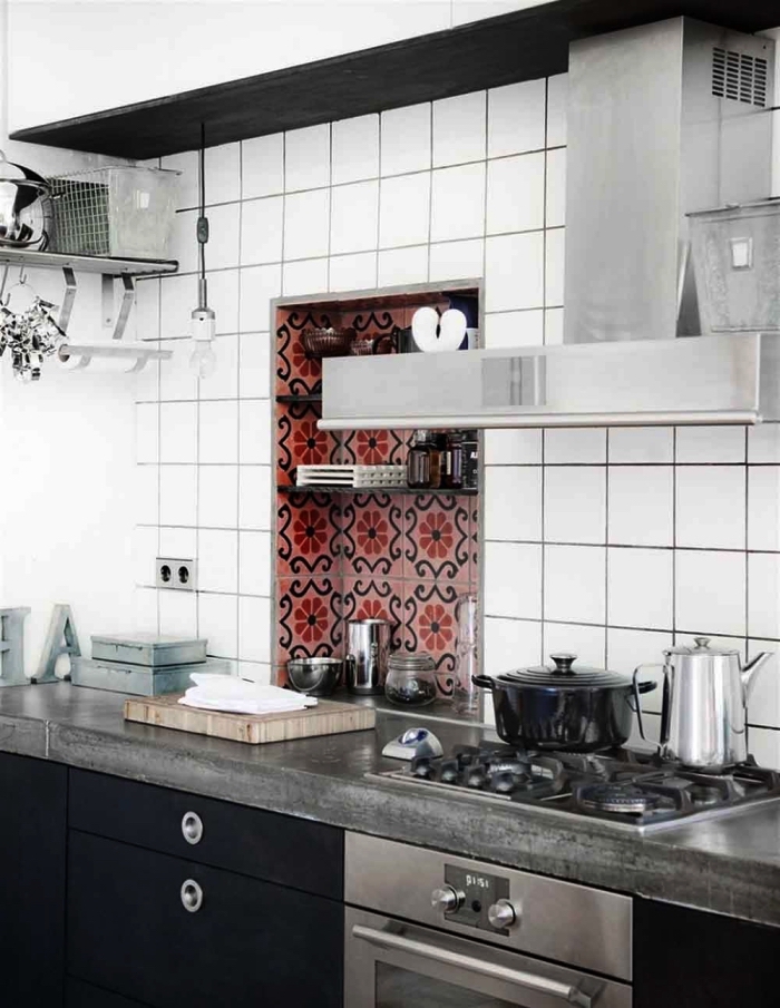 une niche murale mise en valeur par des carreaux de ciment marocains en nuances de rose qui apporte du peps à la cuisine industrielle en noir et blanc, un carrelage imitation carreaux de ciment 