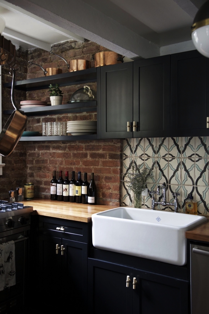 une credence carreau de ciment graphique et vintage en beige et bleu qui apporte une jolie touche déco dans la cuisine en bois et noir de style loft industriel