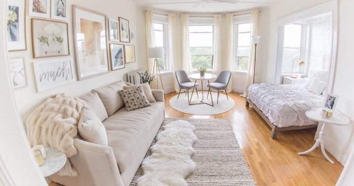 salon gris et blanc avec chambre à coucher design cocooning à coté, canapé grand gris perle. table avec chaises minimalistes
