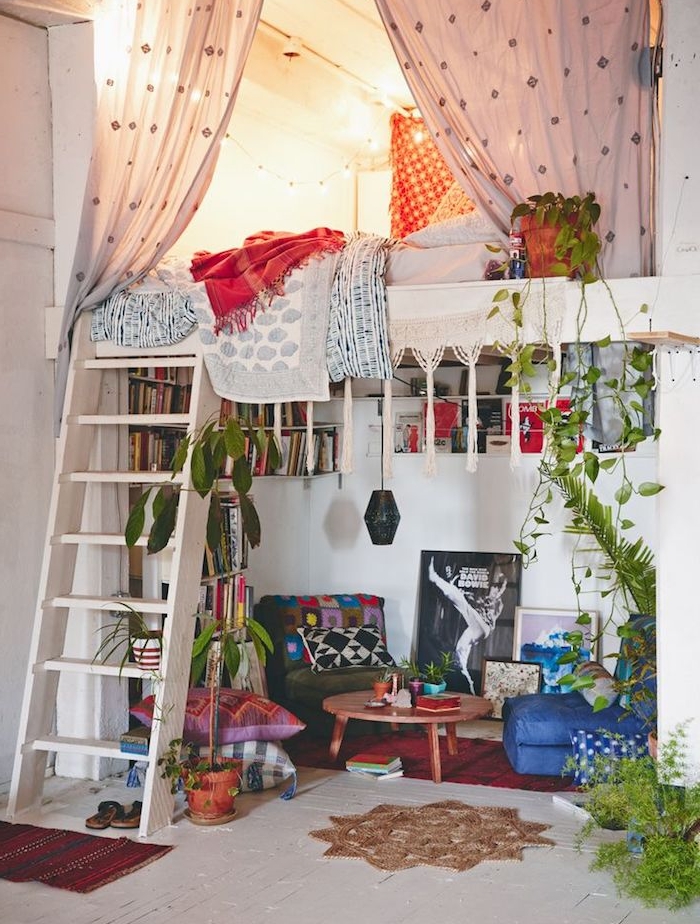 amengement petit espace dans un style deco boheme chic hippie, avex lit mezzanine en hauteur avec escalier et coin salon avec fauteuil, tabouret et table en dessous