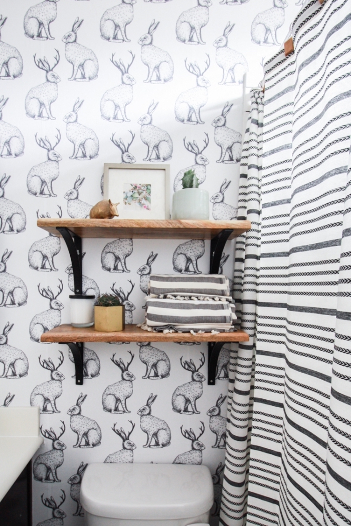 idée revêtement mural pour salle de bain avec papier peint imperméable blanc et noir aux motifs animaux, meuble rangement mural en bois et fer