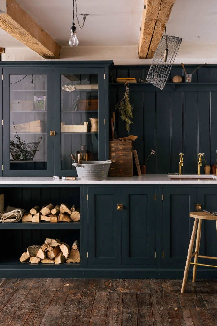 modele de cuisine style rétro chic, armoires de cuisine en vert foncé avec poignées dorées, idée poutres bois apparentes sur plafond