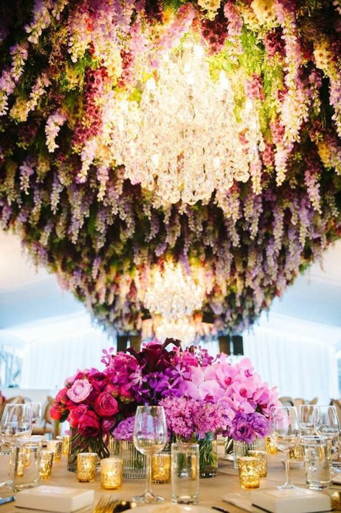 table de mariage romantique, suspension de glycine, bougeoirs dorés, verres à vin, centre de table en rose et fuchsia