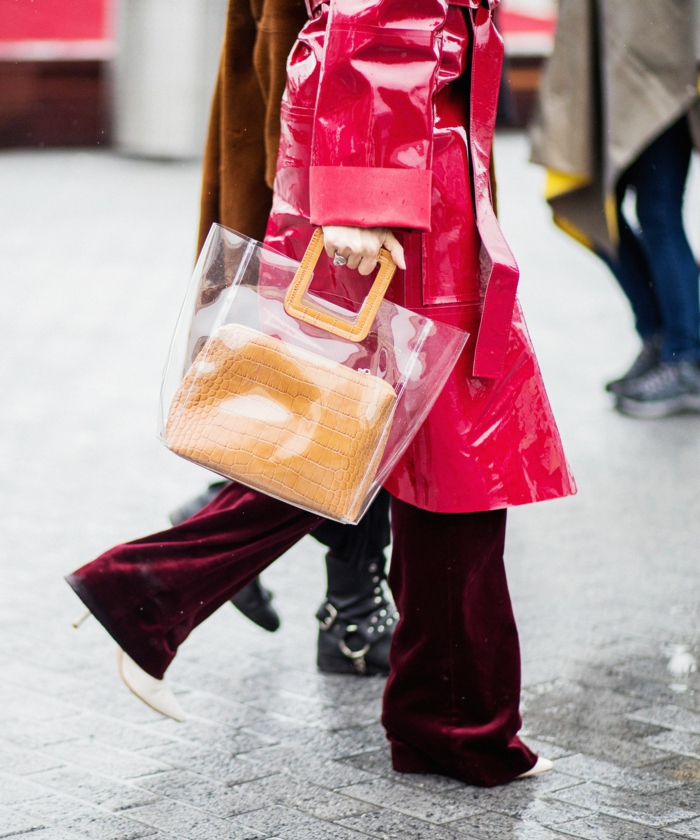 grand sac acrylique porté avec une longue veste imperméable, pantalon en daim burgundy