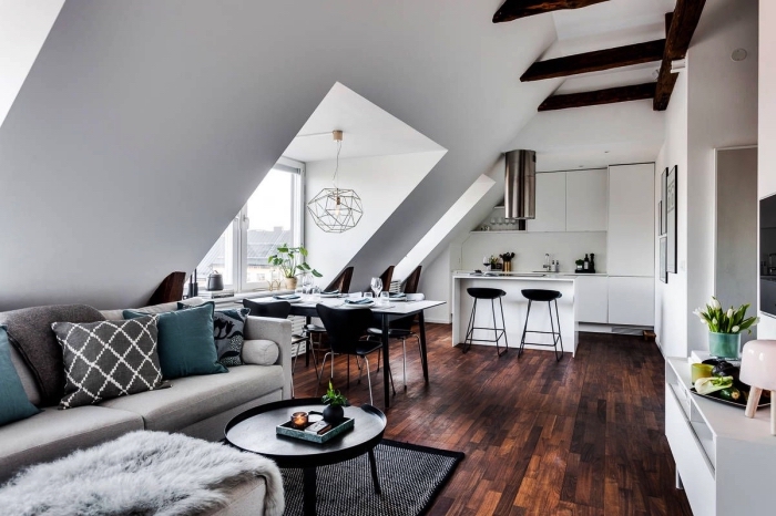 espace ouvert avec salon, cuisine et salle à manger, une chambre sous comble au design scandinave avec une cuisine blanche sur mesure