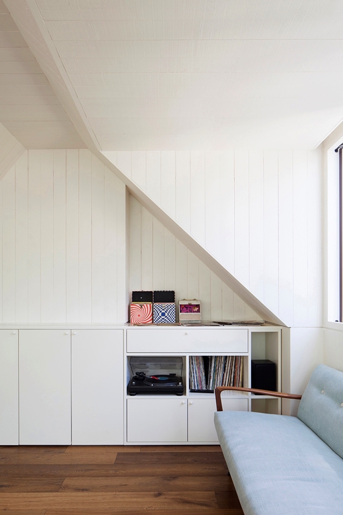 un meuble de rangement sous pente avec niche murale qui offre un espace supplémentaire, coin perdu optimisé dans une chambre sous comble