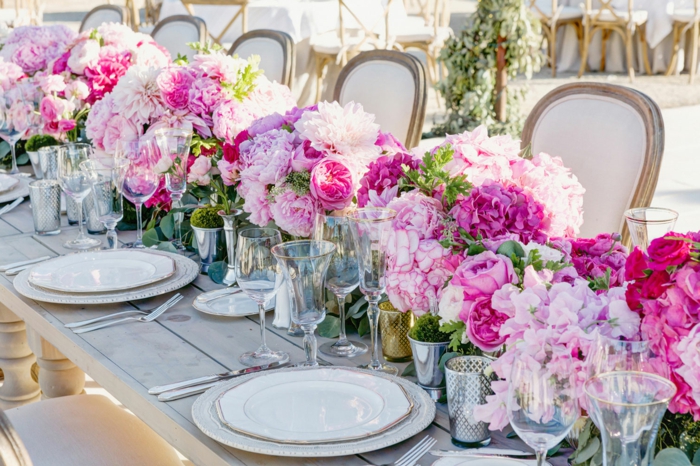 table en bois, assiettes blanches, chemin de table roses et pivoines couleur rose, chaises vintage