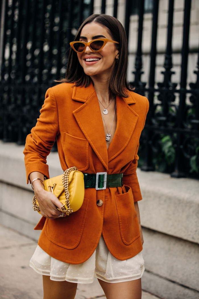 sac bandoulière femme, veste en daim orange, lunettes de soleil cadre orange, jupe mini blanche