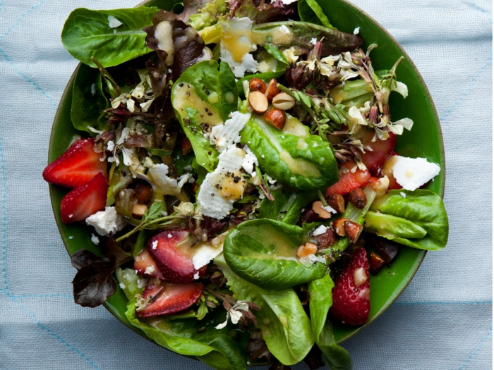 salade légère aux fraises et épinards, fromage de chèvre, assiette verte, salade fraiche joliment servie