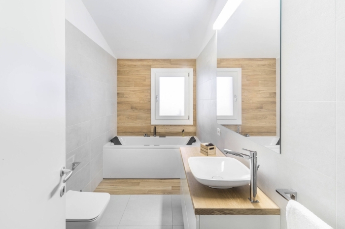 idée salle de bain minimaliste aux murs en carrelage gris clair et peinture blanche avec pan de mur en lambris bois
