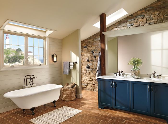 idee salle de bain style campagne chic avec meuble salle de bain bleu nuit et baignoire ancienne sur parquet marron, mur de pierres, lambris blanc