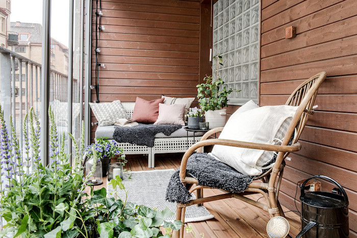 aménager un balcon en longueur avec canapé cocooning avec coussins et plaid gris, chaise de bois design, revetement terrasse en bois, plantes vertes d exterieur