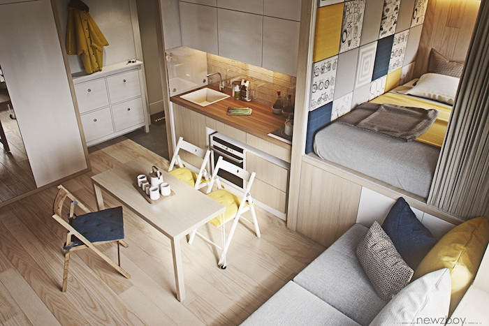 aménagement cuisine petite cuisine en bois avec salle à manger à meubles de bois, lit matelas sur estrade cachée d un rideau gris, accents deco gris, jaune et bleu
