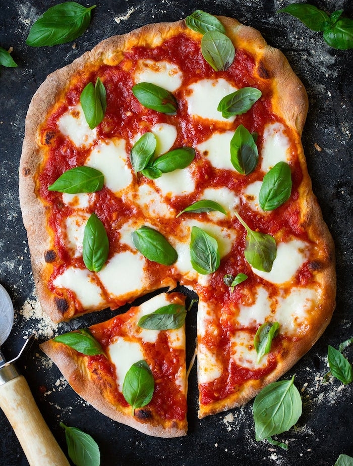 pizza végétarienne margherita aux feuilles de basilic et mozzarella sur de la pâte, idee repas soir recette italienne