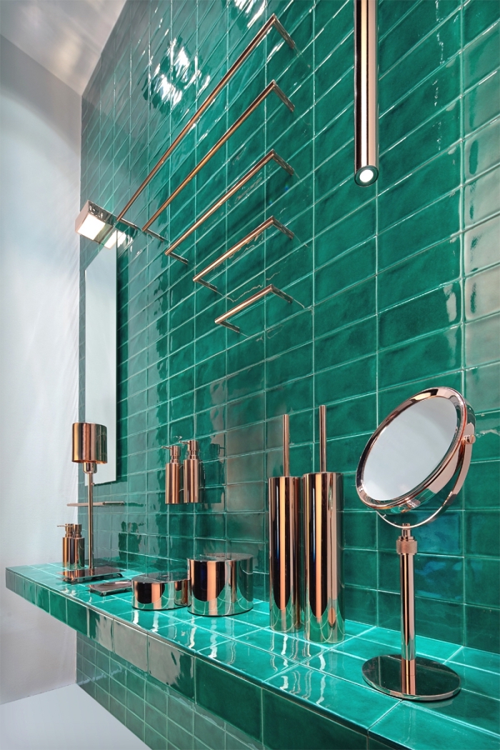 modèle salle de bain moderne aux murs blancs avec revêtement mural partiel en carreaux turquoise, objets en cuivre