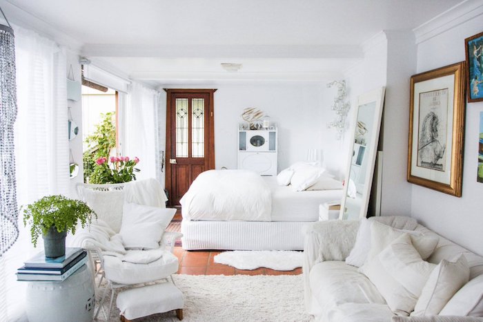 deco chabby chic feminine en blanc avec lit et canapé cocooning en blanc, deco florale, grande miroir et mur de cadres