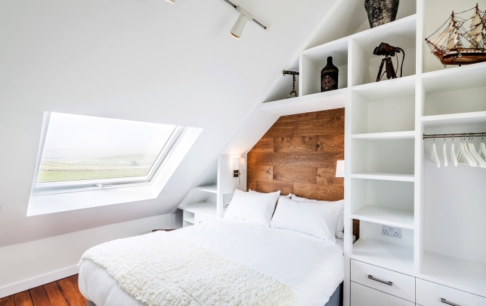 petite chambre à coucher mansardée avec meuble sous pente sur mesure aménagé autour du lit