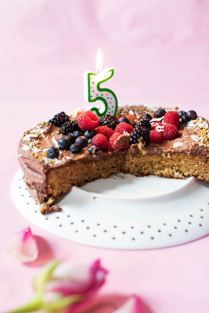 recette sans gluten de gâteau d'anniversaire sans gluten nappé de ganache vegan et décoré de fruits rouges frais
