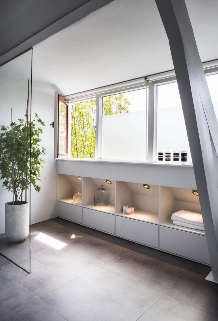 une salle de bains au design moderne avec meuble sous pente intégré au soubassement offrant un espace de rangement supplémentaire 