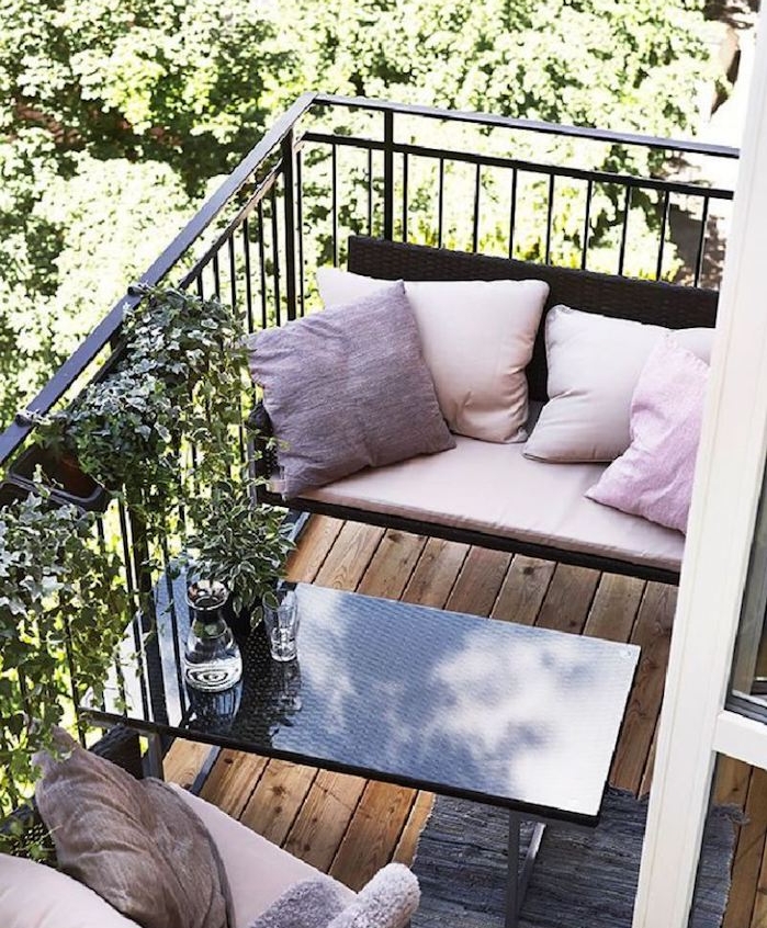 deco de reve, aménagement petit balcon avec des sièges décorés de coussins rose et table basse design couleur noire, revetement terrasse bois