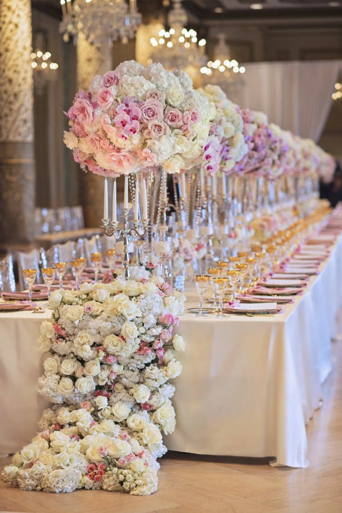 longue table élégante, plafonniers en cristal, grand chemin de fleurs verres aux rebords dorés