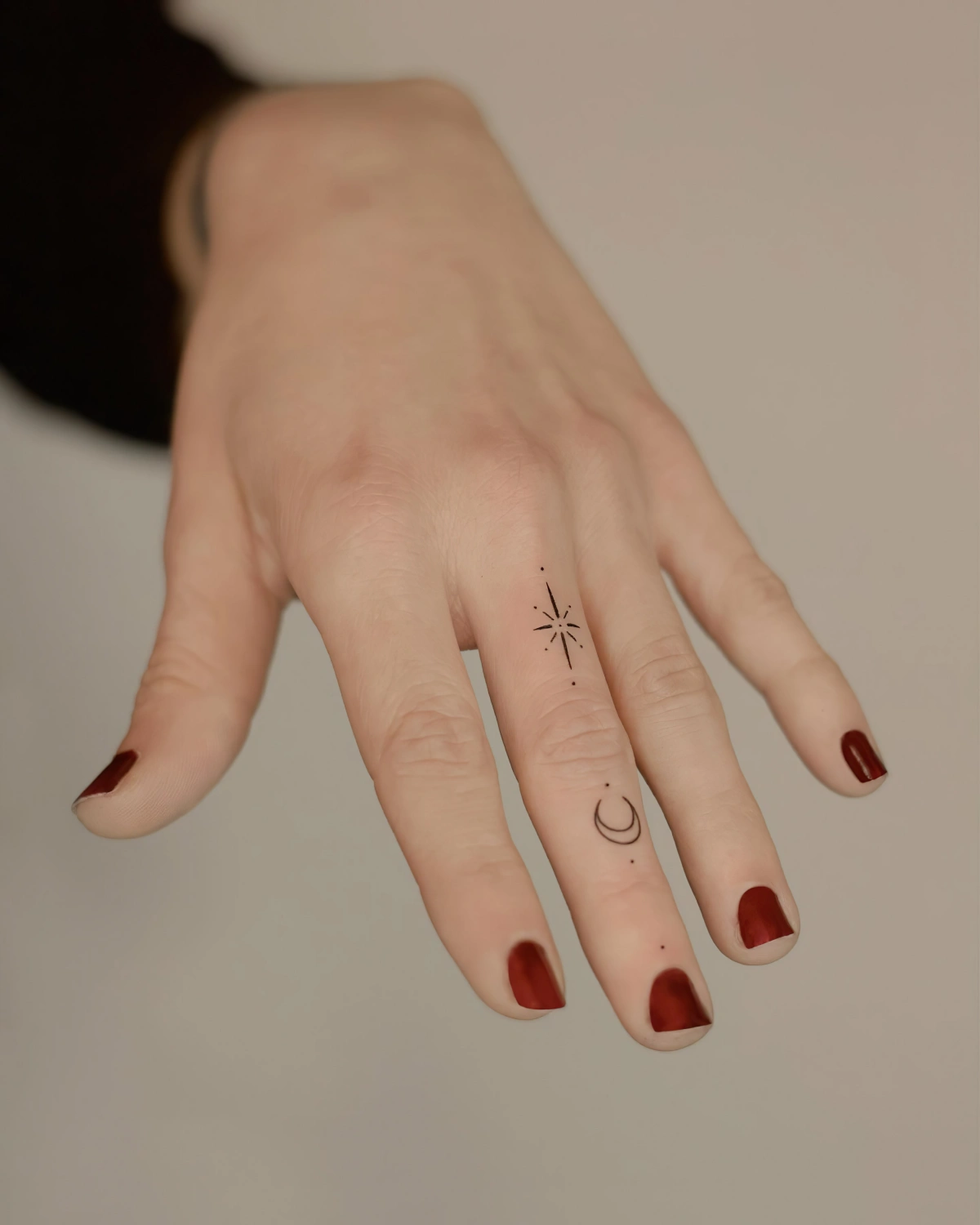 tatouage sur les doigts femme vernis rouge fonce dessin lune