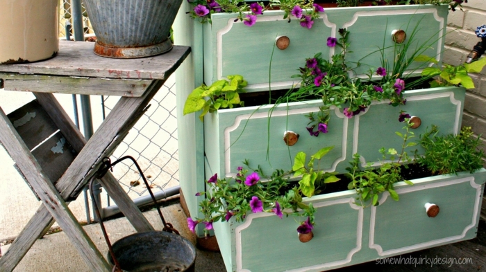 commode avec placards bleus aux poignées métalliques, tiroirs transformés en jardinières