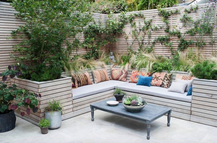 palissade avec des plantes grimpantes dans une cour arrière zen, aménagement jardin extérieur avec meubles bois