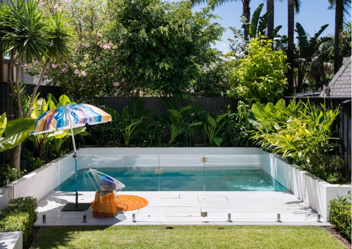 decoration exterieur avec piscine et plage bois, créer un bassin dans sa cour arrière, déco de jardin avec gazon et plantes exotiques
