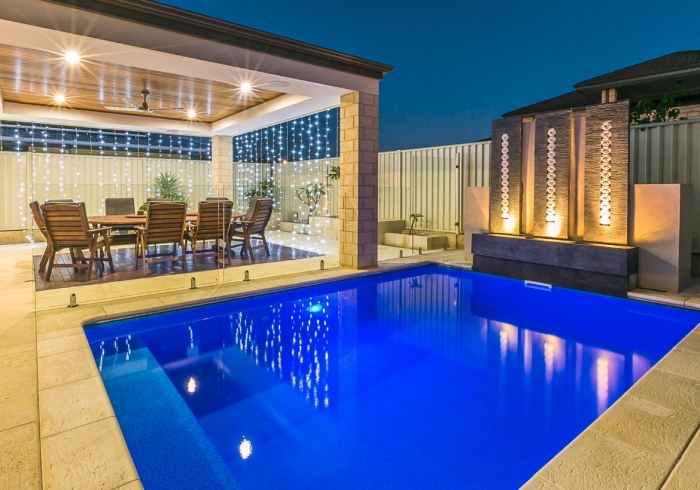 amenagement piscine avec mur pierre à éclairage moderne, décoration espace extérieur avec piscine et pergola