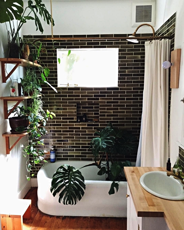 idée d'aménagement d'une petite salle de bain 4m2 avec baignoire, carrelage en nuances du vert foncé et un décor végétal de pots de plantes