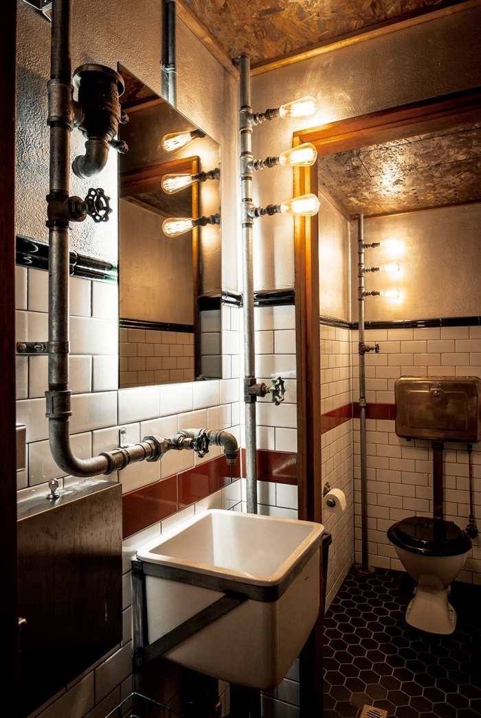 comment décorer une salle de bain de style industriel, petite salle de bain aux murs dalles blanches avec tuyaux gris