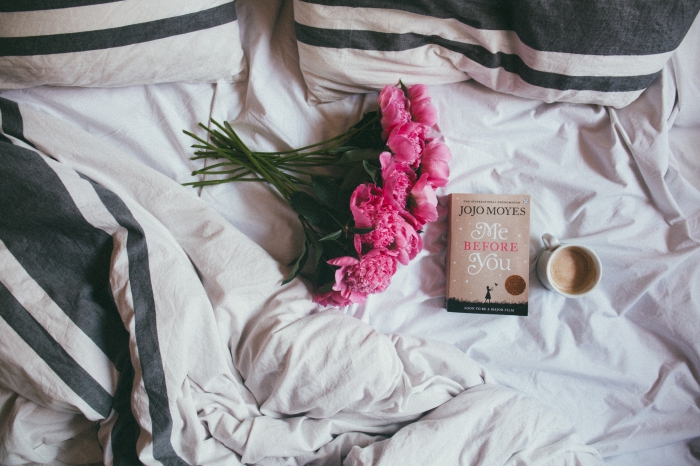 customiser son écran pc avec une photo cocooning, exemple photographie ambiance cozy dans un lit avec livre et café