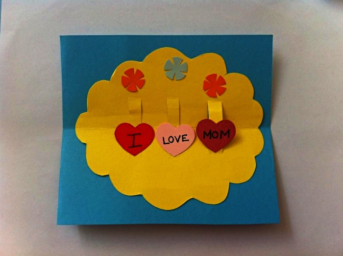 une carte pop-up à fabriquer avec les enfants à l'école maternelle, carte pour la fête des mères avec petit mot doux écrit sur coeurs en papier