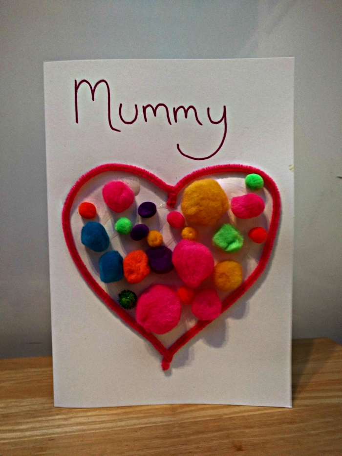 activité manuelle facile 3-5 ans à l'occasion de la fête des mères, carte avec cœur en cuire-pipe et des pompons colorées à l'intérieur