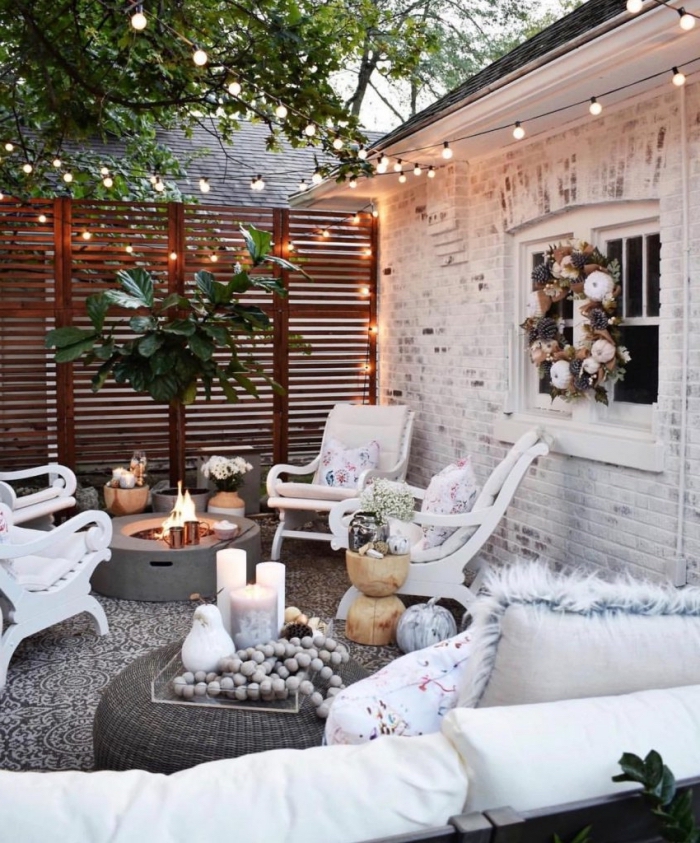 deco exterieur maison avec façade en briques blanches, ambiance cozy dans la cour arrière avec feu béton et chaises blanches