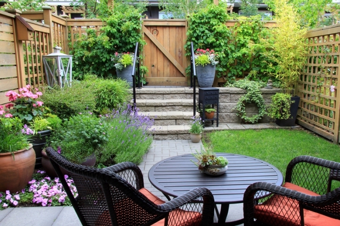 idee deco jardin avec pelouse, exemple de petit jardin aménagé avec chaises tressés et table ronde, quelle plante pour jardin