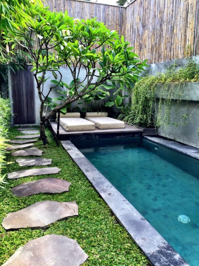 modèle amenagement piscine de style zen et minimaliste, cour arrière avec piscine et transat, allée en grandes dalles dans le jardin