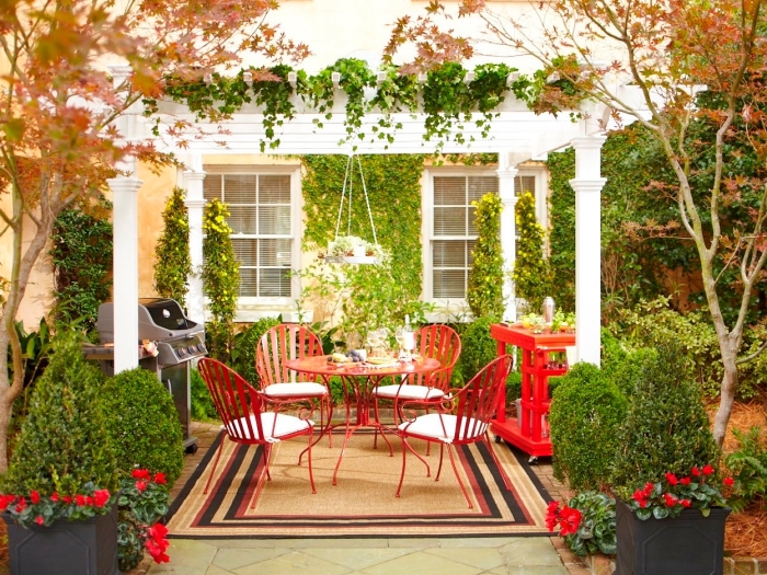 exemple comment décorer une pergola, idée salon de jardin en couleur rouge, diy suspension florale, coin repas extérieur