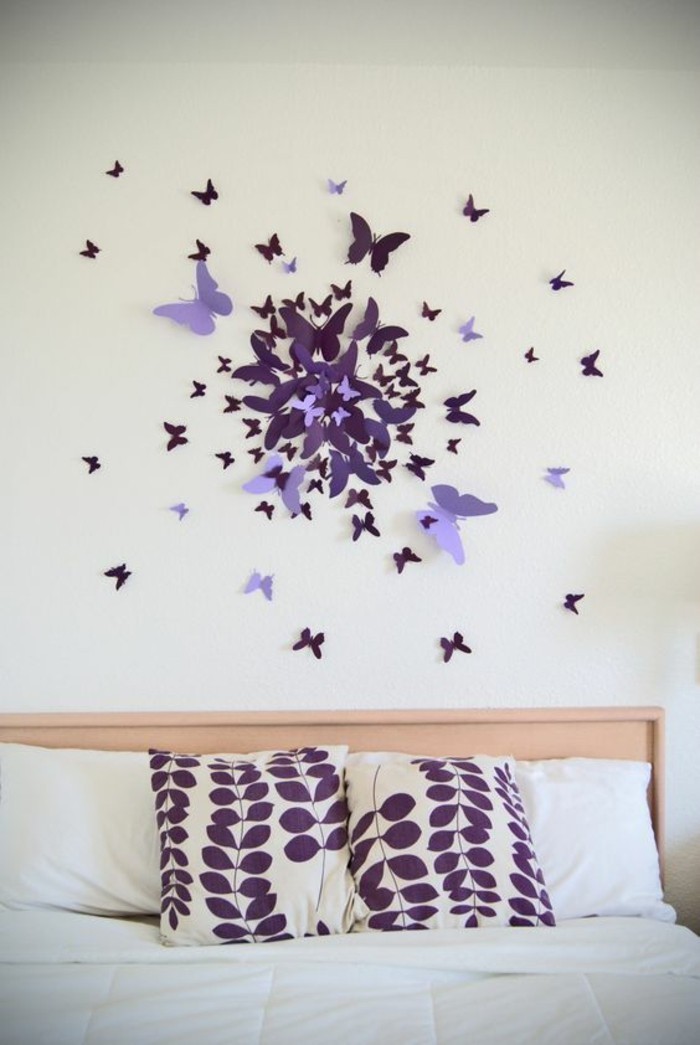 diy déco chambre, papillons bricolés de papier au-dessus du lit sur le mur blanc, coussins motifs floraux