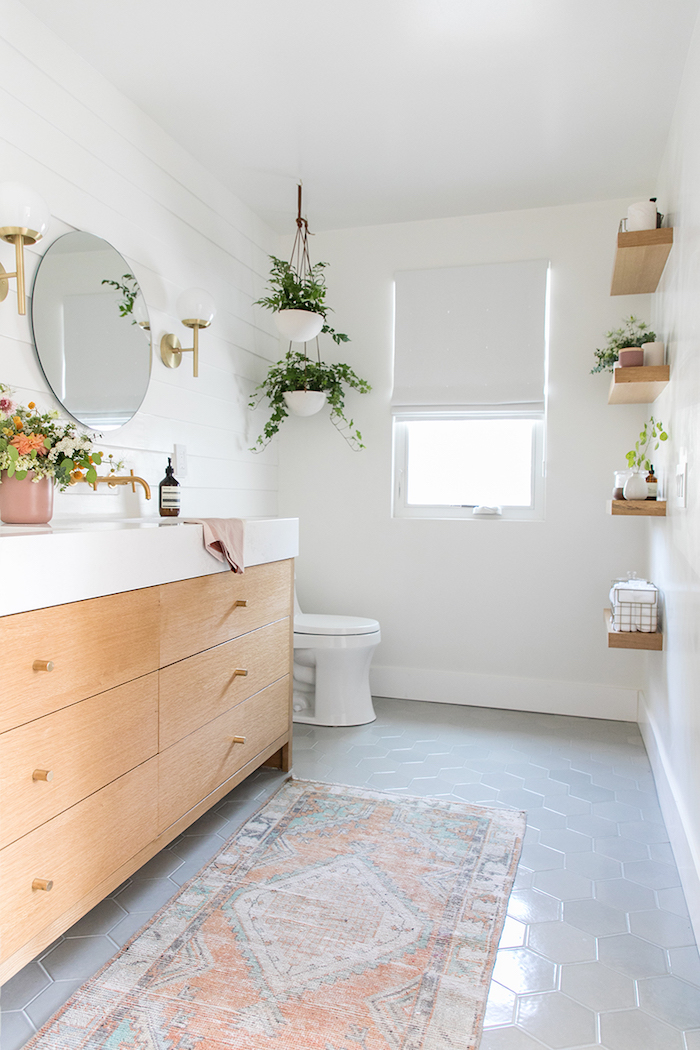 Plantes vertes decoration petite salle de bain, une salle de bain moderne, miroir ronde, meuble avec placards en bois et marbre blanche pour le lavabo