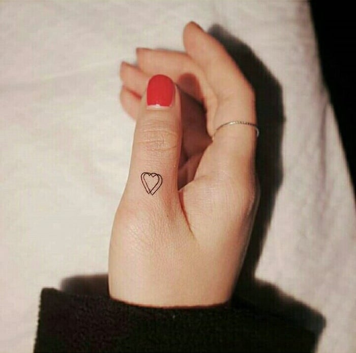 Double coeur minimaliste sur le doigt, vernis à ongles rouge, tatouage phrase, tatouage old school, personnaliser son tatouage