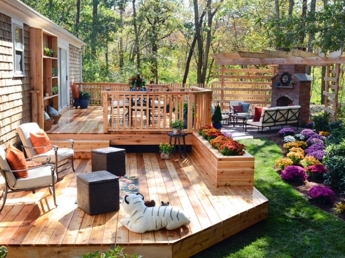idée aménagement extérieur avec terrasse en bois et pergola, jardin avec cheminée, meubles de jardin en fer forgé