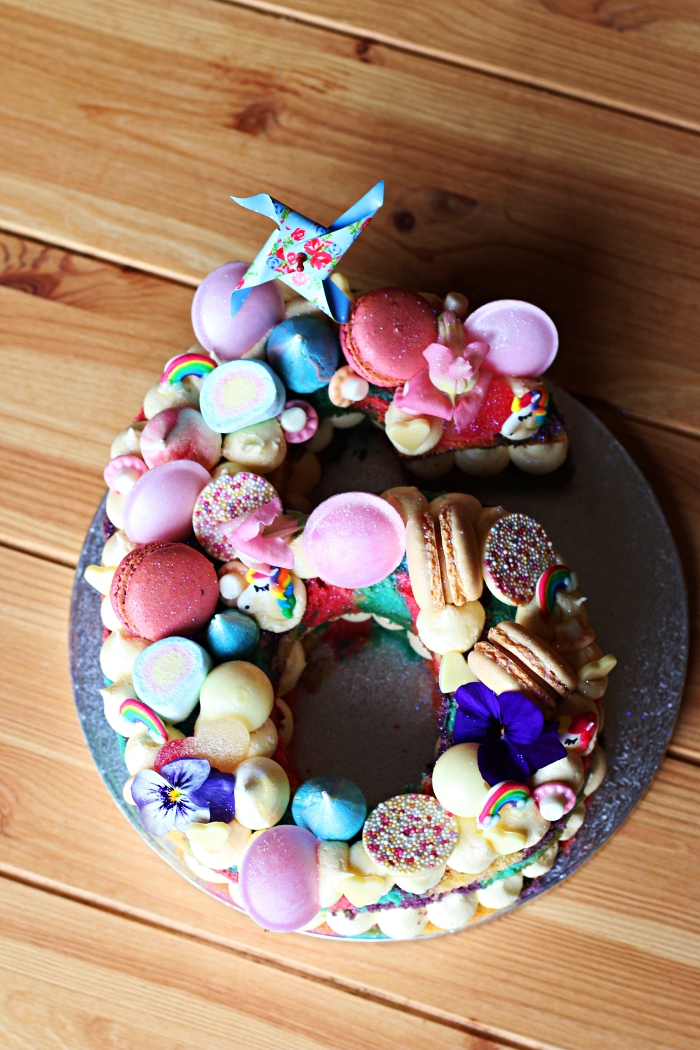 gateau anniversaire enfant en forme de chiffre décoré de toutes sortes de confiseries, de macarons et de crème beurre, idée gâteau anniversaire 6 ans pour fille