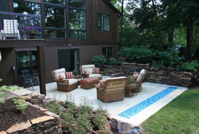 comment décorer une terrasse dalles avec meubles tressés et petit bassin, exemple déco de la cour arrière relaxante