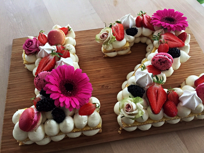 gateau anniversaire facile sur une base de biscuit garni de meringues en buttercreal, macarons et fruits rouges