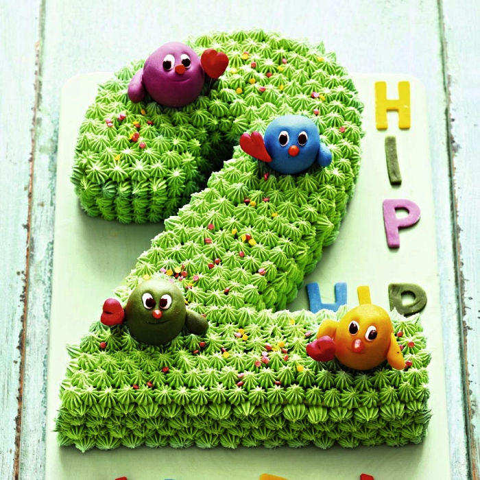 gateau anniversaire enfant 2 ans en forme de chiffre recouvert de glaçage décoratif vert et décoré de figurines en pâte d'amande