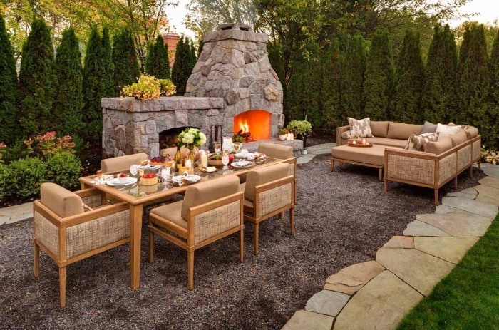 exemple d'aménagement jardin extérieur avec cheminée, salon de jardin en bois clair et beige, table à manger pour extérieur