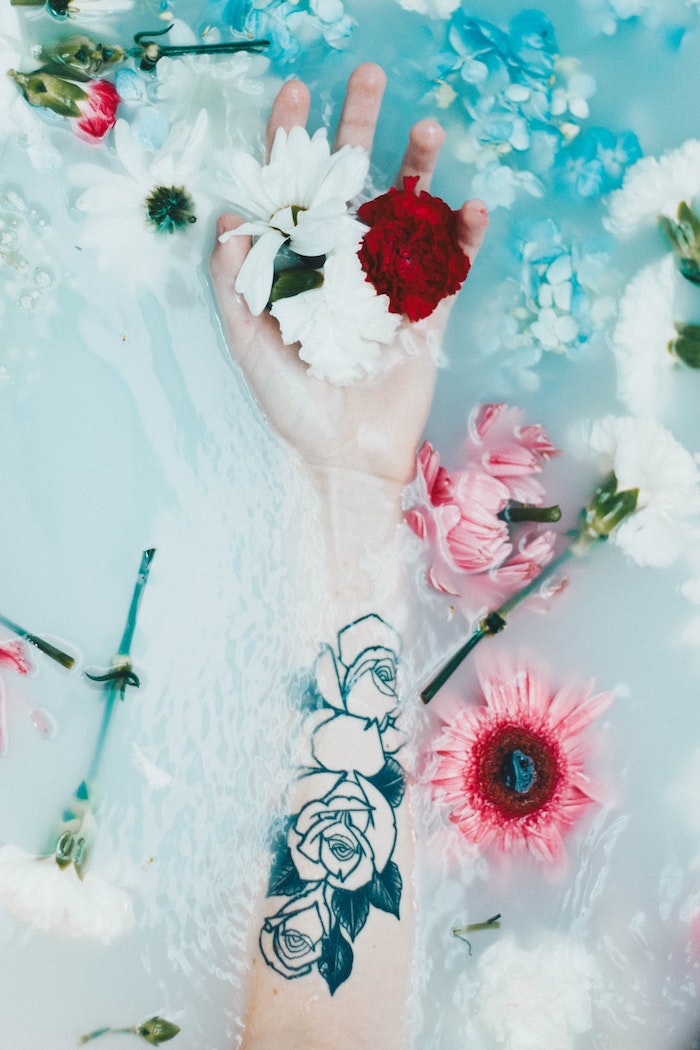 Main dans un baignoire et fleurs dans l'eau tatouage fleur rose, tatouage dessin, la signification de mon tatou